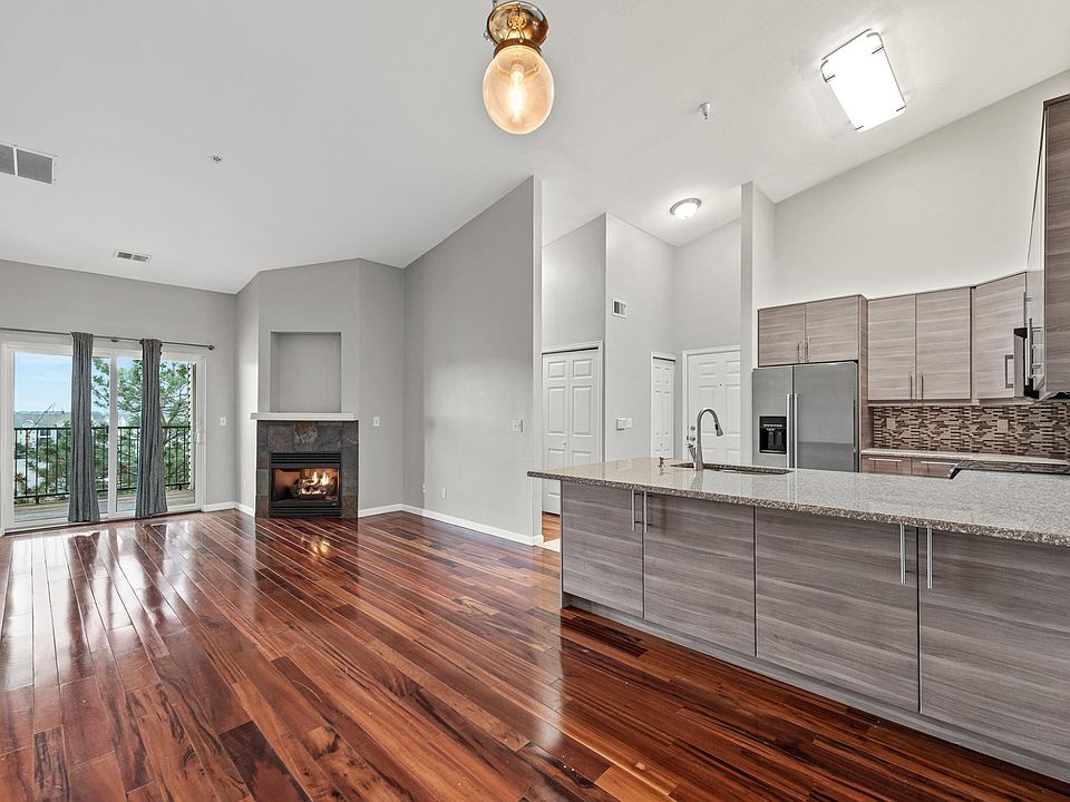 View of the open concept living area from the dining room with gorgeous gas fireplace and view off the spacious deck.