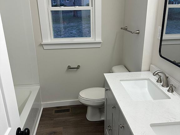 Bathroom with dual sinks and tub/ shower.