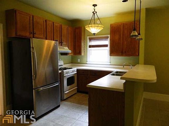 Renovated kitchen with breakfast bar opening to den