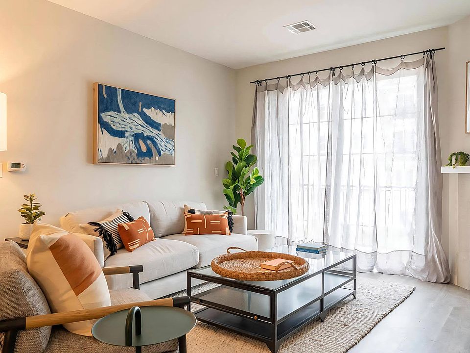 Modern Living Space with White Sofa, Patterned Pillows, and Natural Light