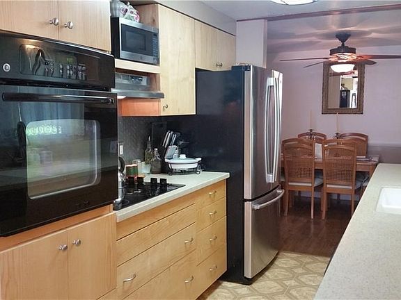 Remodeled kitchen has maple cabinets, Corian counter tops and stainless steel backsplash.