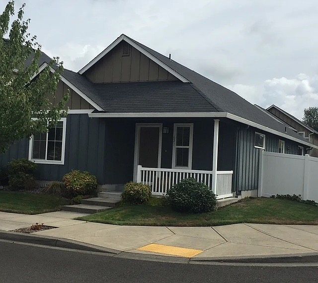 Front of house with porch on corner lot with fenced back yard.