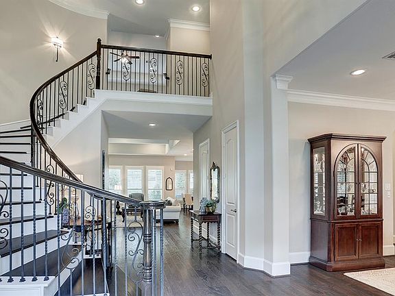 Upon entering this absolutely fabulous home, you will find a lovely curved stairway with hardwood treads (upgraded in 2019) and wrought-iron balustrade.
