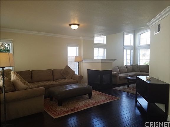 Open floor plan. Family room and living room separated by 3-way fireplace. Family room has door leading to backyard.