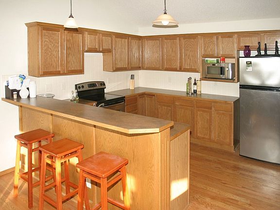 Kitchen With Hardwood Floors and Eating Bar