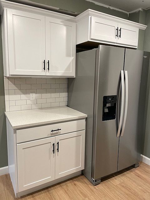 Kitchen features luxury vinyl plank, stainless steel appliances and quartz countertops