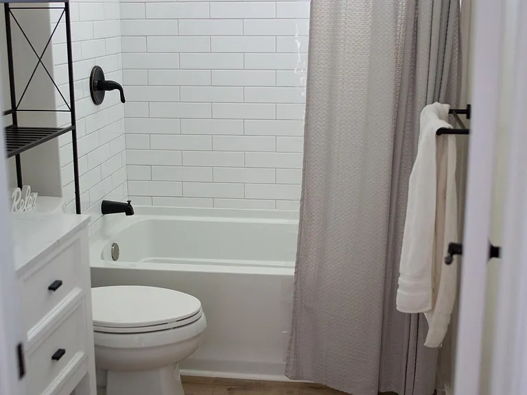 2nd bathroom with tub, shower/sprayer combo, subway tiles and waterproof Pergo floors.