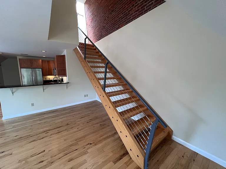 Stairs lead to second floor bedroom with attached full bathroom