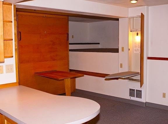 Fold down wall bed, also shown is a loft area which can be used for sleeping and or storage and fold down ironing board.