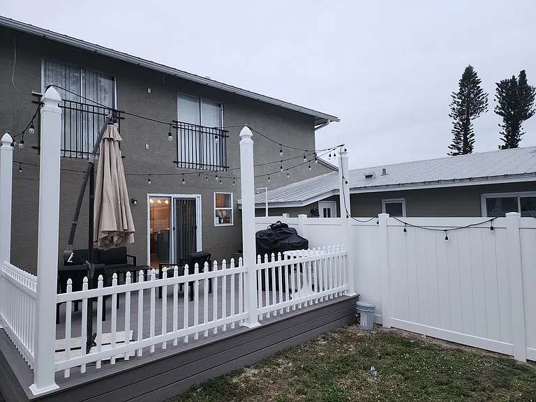 Outdoor deck with patio furniture, umbrella, and gas grill.