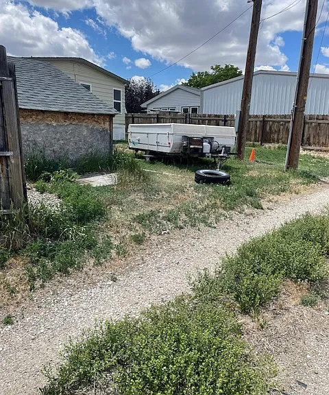 View of shed in the rear of house. Trailer is no longer present providing overflow parking in the rear of the house.