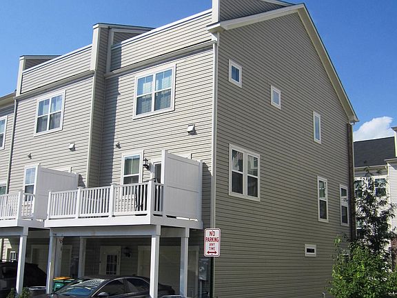 Back of house with driveway & garage and main level & top level deck