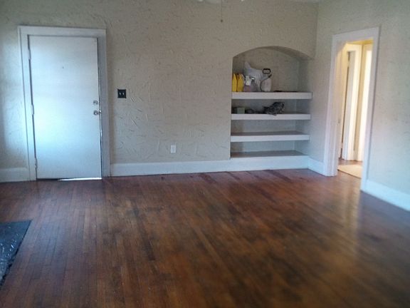 Living room facing west. large built-in shelves, use as an entertainment center or bookcase