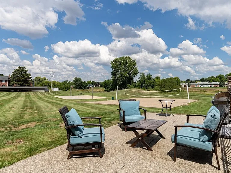 Photo of the clubhouse grounds, with seating an volleyball courts