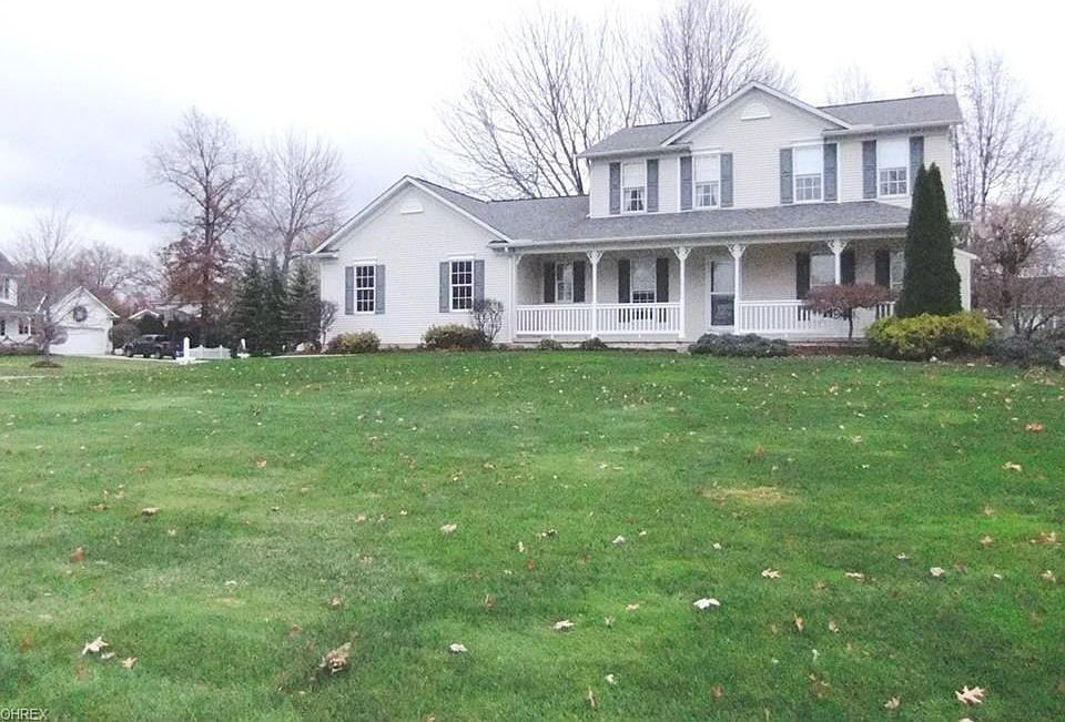 Front of home with side load garage and full front porch.