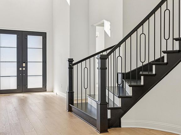 Beautiful curved staircase and double iron front door
