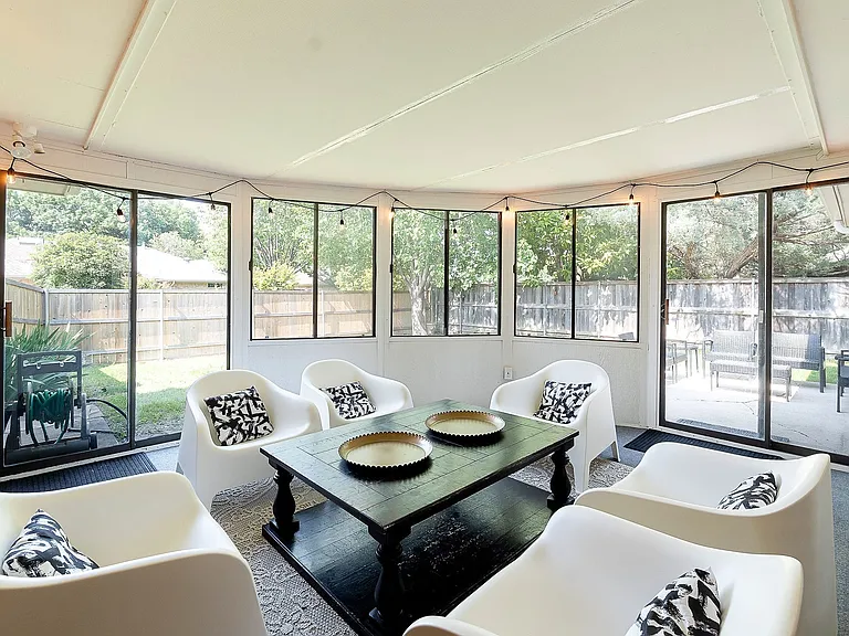 Sunroom / solarium with many windows looking out to fenced back yard