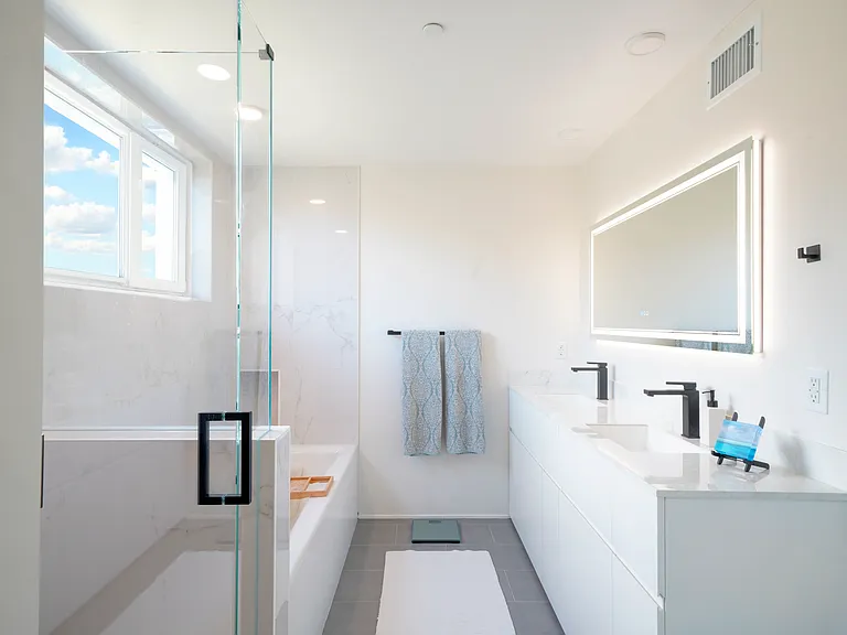 Primary bathroom with shower and bathtub. Touch mirror with dimmable light and defogger