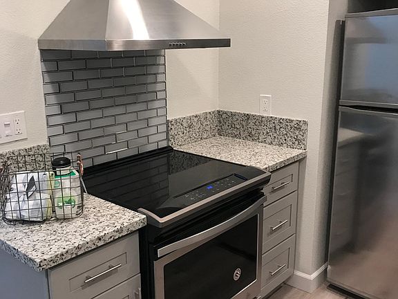 Kitchen with soft close gray cabinets, electric glass top stove top and ovene