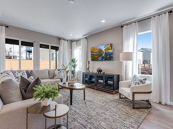 A cozy and well-furnished living room with comfortable seating, a decorative cabinet, and a vibrant