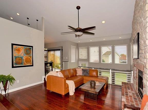 Taller ceiling adds volume to this sunken great room with beautiful hardwood, brick/stone floor to ceiling fireplace with media nook, recess lighting and ceiling fan.