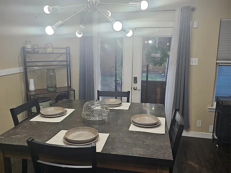 Dining space featuring dark wood-style flooring and a chandelier