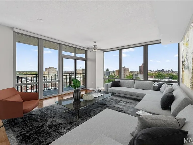 Open-concept living space featuring expansive floor-to-ceiling windows, wood-finish flooring, and a sliding glass door leading to a private balcony