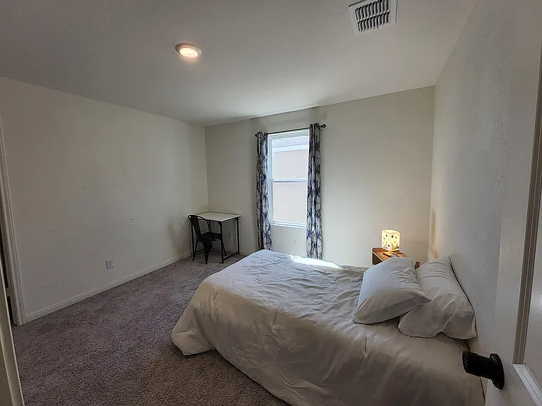 This room has a desk and drapes giving you space to get computer work done.
