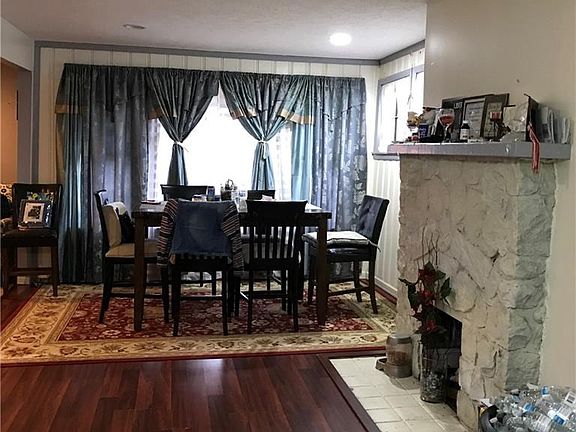 Dining area w/laminate flooring, unique fireplace.