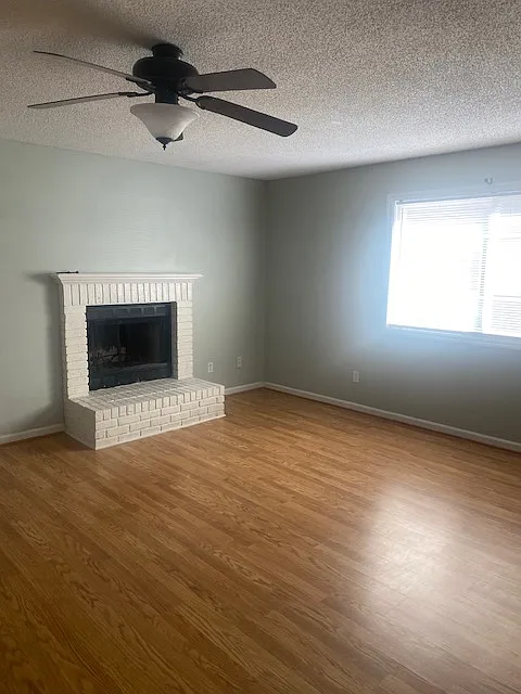 Den with laminate flooring and ceiling fan