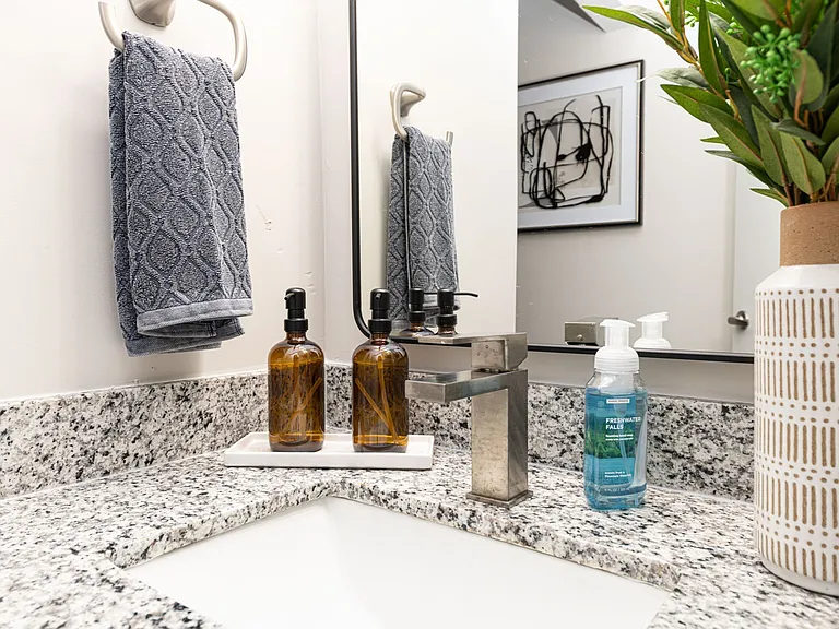 Bright bathroom with granite counters and high rise faucet