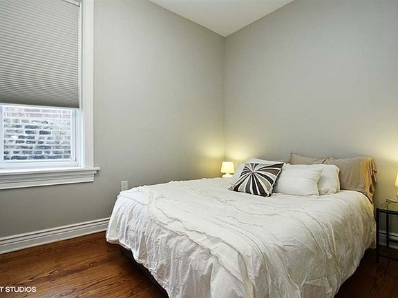 The primary bedroom, located just off the kitchen, comfortably fits a queen-size bed and features a large closet with a built-in organizer designed to maximize clothing storage.