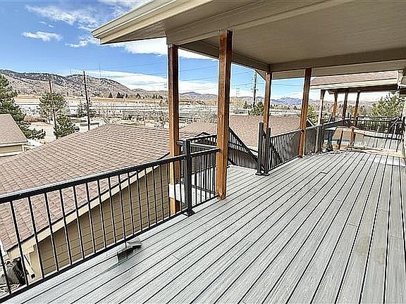 Expansive covered balcony with scenic mountain views, perfect for outdoor relaxation.