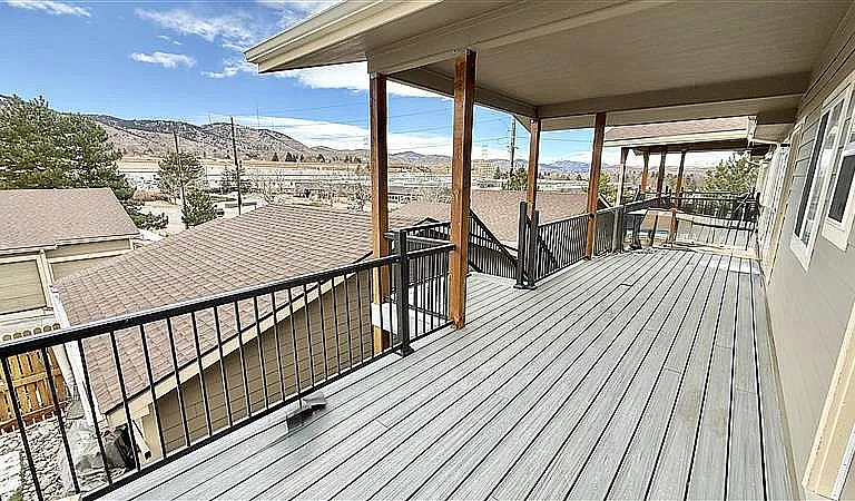 Expansive covered balcony with scenic mountain views, perfect for outdoor relaxation.