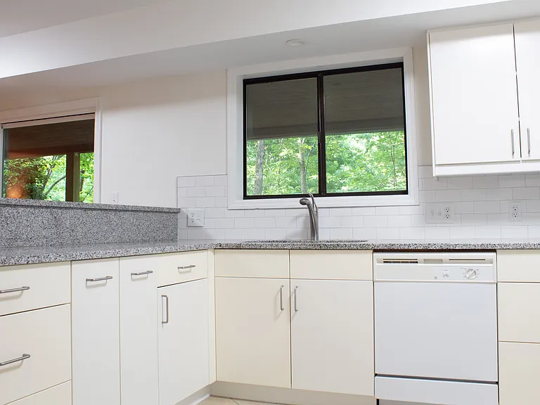 The kitchen also features a lot of storage space under the large granite countertop.