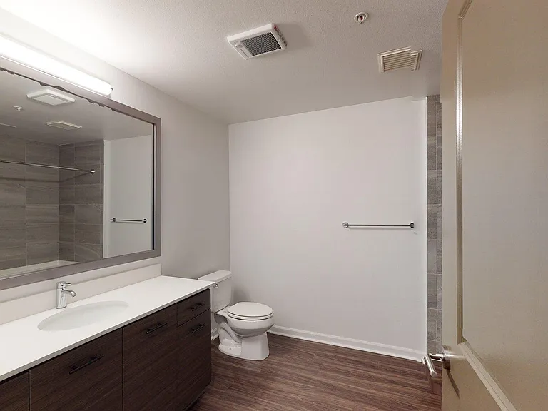 Apartment Bathroom with Wood Style Flooring.