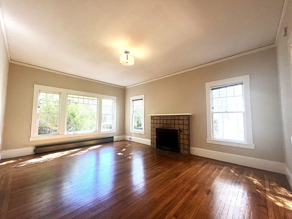Spacious Living Room with Walls of Windows and Decorative Fireplace