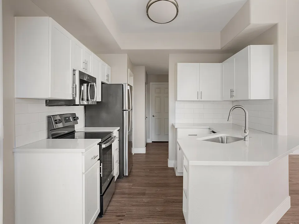 Kitchen area that leads to a spacious balcony with its own storage close