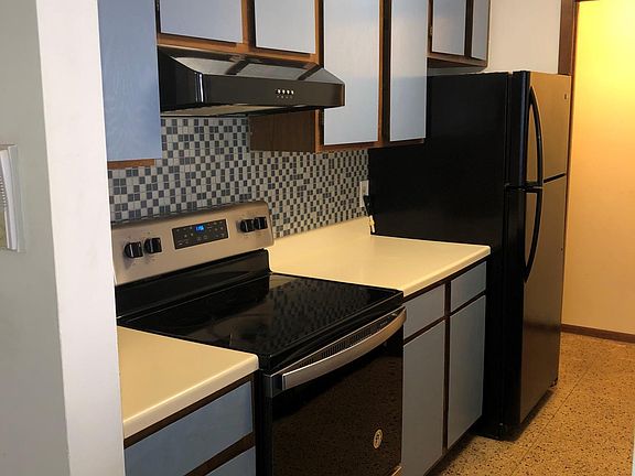 Kitchen stove side leading into walk-in pantry.
