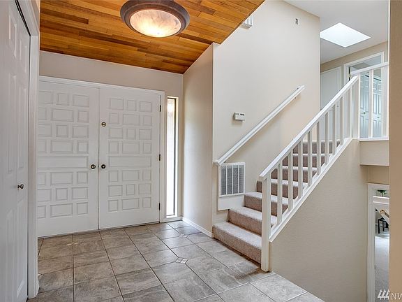 Gorgeous tile entry with cedar tongue and grove ceiling. The skylight in the staircase makes it so light and bright.