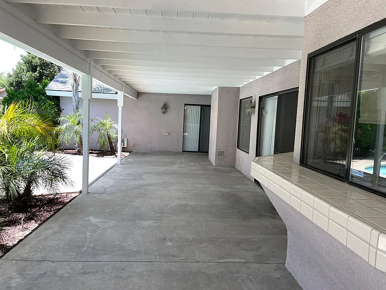 Large rear patio for outdoor furniture and counter connecting with the kitchen