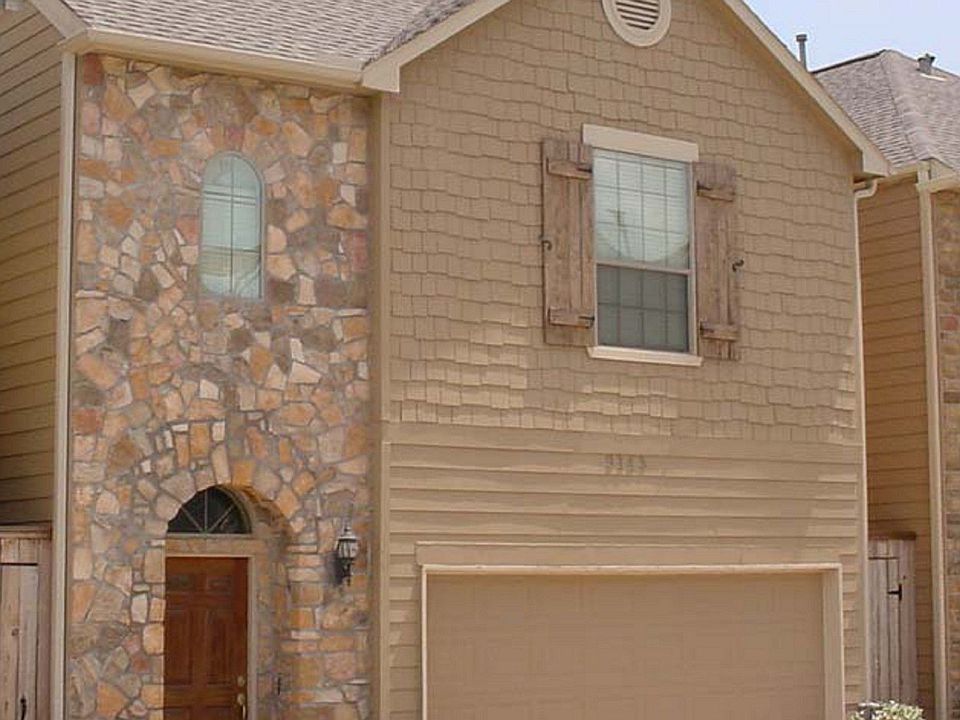 Tri-level stucco/stone home nestled in a gated lake community 