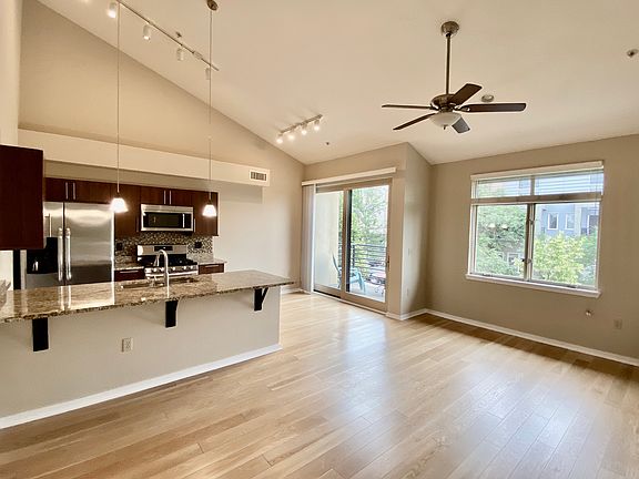 Hardwood floors and wall of oversized windows in main living area.