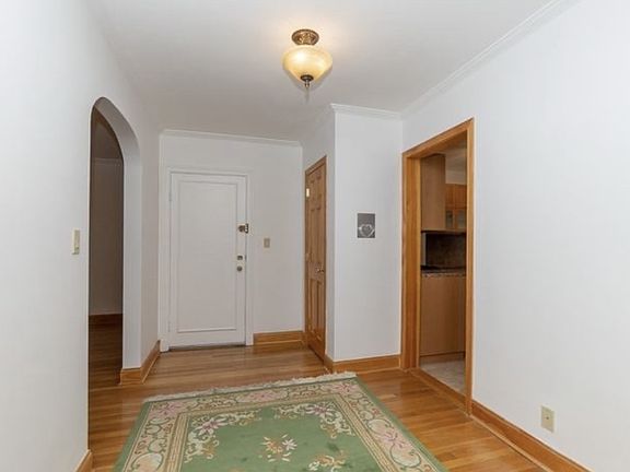 View of entryway from back wall. Living/dining on left, kitchen on right, entryway closet on back right.