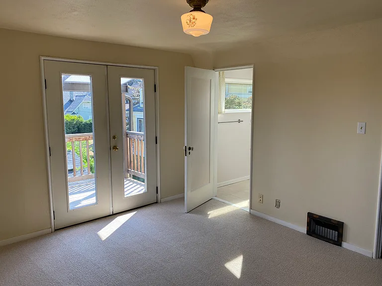 Primary suite upstairs with a covered balcony and large bathroom and partial views of downtown Seattle, Bellevue and Mount Rainier