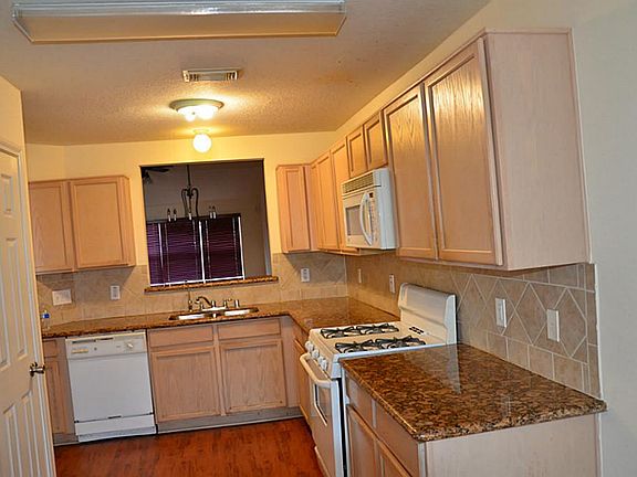 Kitchen,Granite counter top,Tiled back splash,Micro-oven Exhausting out sideServing window/Breakfast bar open to Formal Dining room.Rich Laminate flooring
