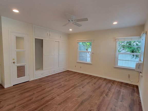 bedroom showing closet and drawers on the left side and the window air conditioner on the right side of the picture. 2 out of the 5-bedroom windows are visible in the picture