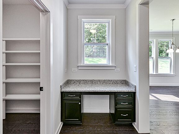 Planning room off of kitchen with built-in desk, window and adjacent walk-in pantry.