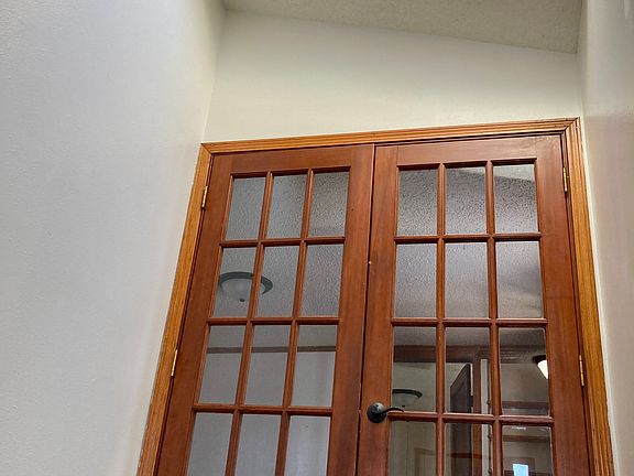 French doors with a skylight window above, opening into a versatile space ideal for a second living room or formal dining area.