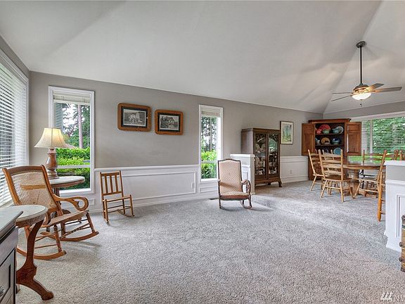 Step down living room with wainscoting and vaulted ceilings.
